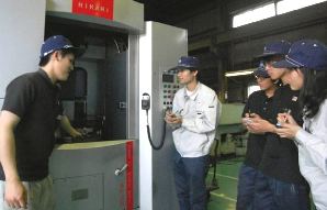 光機械製作所では先輩の若手社員(左)が、新入社員らにアドバイスするなど、独自の研修プログラムを取り入れている＝津市一身田中野で