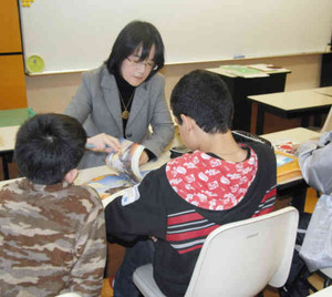 「虹の架け橋教室」で、日本人教師と日本語の勉強をする外国人児童ら＝豊橋市内で