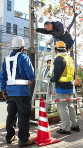 商店街のクリスマス電飾を取り付けるジョブトレ参加者ら＝東京都立川市で
