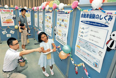 保険の仕組みなどのクイズに挑戦する親子＝東京都新宿区の損保ジャパンで