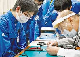 村瀬さん（右）の説明を熱心に聞く学生ら＝関市迫間の中日本航空専門学校で
