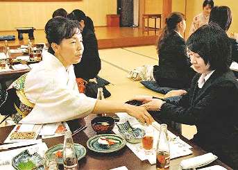 食べ終わった料理の皿の位置を学生に指導するおかみの中村さん（左）＝大垣市高砂町の料亭「助六」で