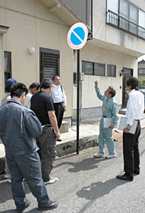市職員から市道の道路標識のチェック点について説明を受ける臨時職員ら＝金沢市上柿木畠で