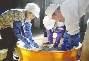 大だらいで米を洗う参加者ら＝美濃市相生町の小坂酒造場で
