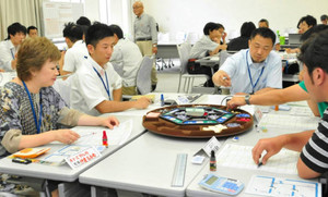 卓上ゲームをして会社経営を考える受講生ら＝鈴鹿市御薗町のスポーツマンハウス鈴鹿で