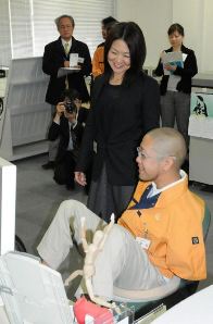足でパソコンを操作して業務に取り組む従業員と談笑する佐藤真海さん㊥＝南区立脇町の中電ウイングで