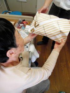 次男から、母の日の贈り物を受け取って喜ぶ女性。次男は介護に悩む日々を送った＝名古屋市内で