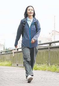 訪問介護事業所の制服姿でヘルパーの仕事先に向かう水沼さん＝いずれも東京都内で
