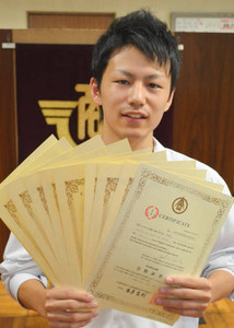 取得した９種目の合格証書を手にする蝦名君＝東海市の東海商業高で