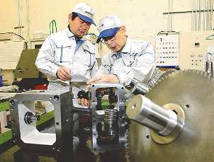 定年制がなく還暦を超えても働く熟練社員と話す西島篤師社長（左）＝愛知県豊橋市石巻西川町の西島本社で