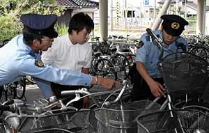 駐在所勤務の署員と一緒に防犯点検をする小杉高の原田君（中）＝射水市のＪＲ小杉駅前駐輪場で