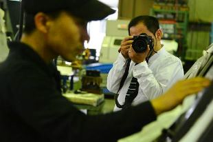 職場で働く姿を形に残す「職撮」の会社を立ち上げた山中さん（奥）＝四日市市内で（サンワークス提供）