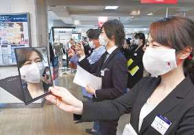 開店前、マスク姿で笑顔のトレーニングをする従業員＝名古屋・名駅の名鉄百貨店本店で
