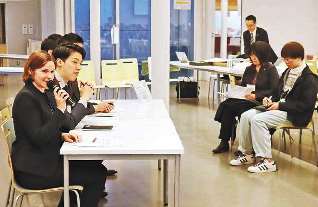 留学生に日本での仕事について話す外国人社員（左側）＝名古屋市千種区の名古屋大で