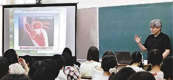 心臓の構造について生徒に説明する駒田さん（右）＝津市河辺町の津西高校で