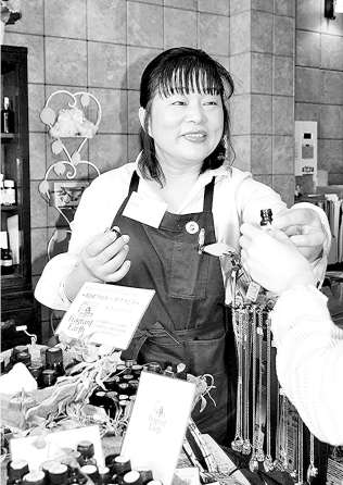 お客さんの悩みや症状に合わせて精油を選ぶ竹田友枝さん＝豊橋市駅前大通の「＆Ｂｌｕｅ」で