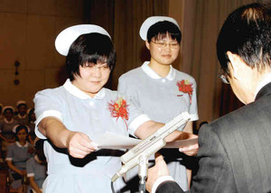 卒業式で西尾幡豆医師会長から特別賞を贈られる佐藤利恵子さん（左）と優貴さん＝西尾市の西尾幡豆医師会准看護学校で