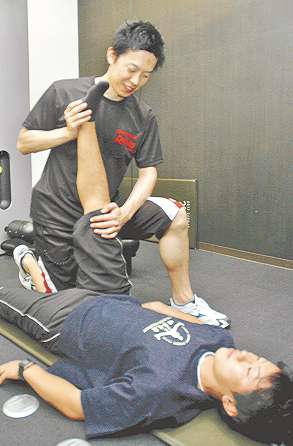 太もも裏の筋肉のストレッチをする安井さん（手前）と大津さん＝豊川市末広通のアイレクススポーツクラブで
