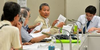 派遣労働者の実態について話す県労働組合総連合の榑松佐一議長（右から２人目）＝名古屋市熱田区の県司法書士会館で
