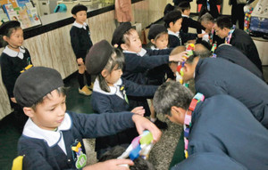 感謝を込めて作った首飾りをお巡りさんに贈る園児たち＝高岡署で