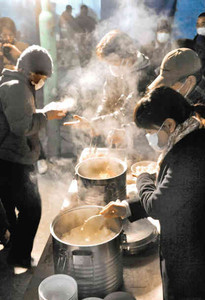 「名古屋越冬活動」の炊き出しで、温かい食べ物を配る支援者ら＝２８日夜、名古屋市中村区名駅の西柳公園で（山田欣也撮影）
