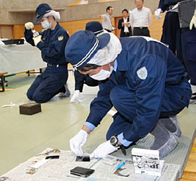 真剣な表情で鑑識作業をする署員＝金沢市で