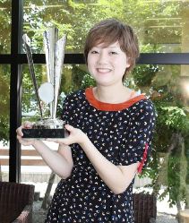 優勝トロフィーを手に笑顔を見せる杉本亜弥さん＝西尾市吉良町のヴィヴァーチェで